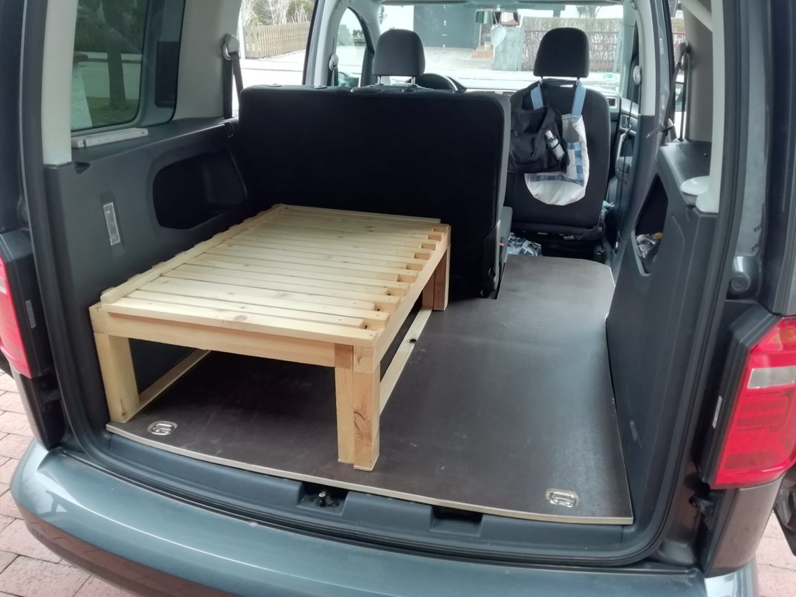 Ausziehbett hinter Rücksitzbank mit ausgeparter Bodenplatte im Caddy